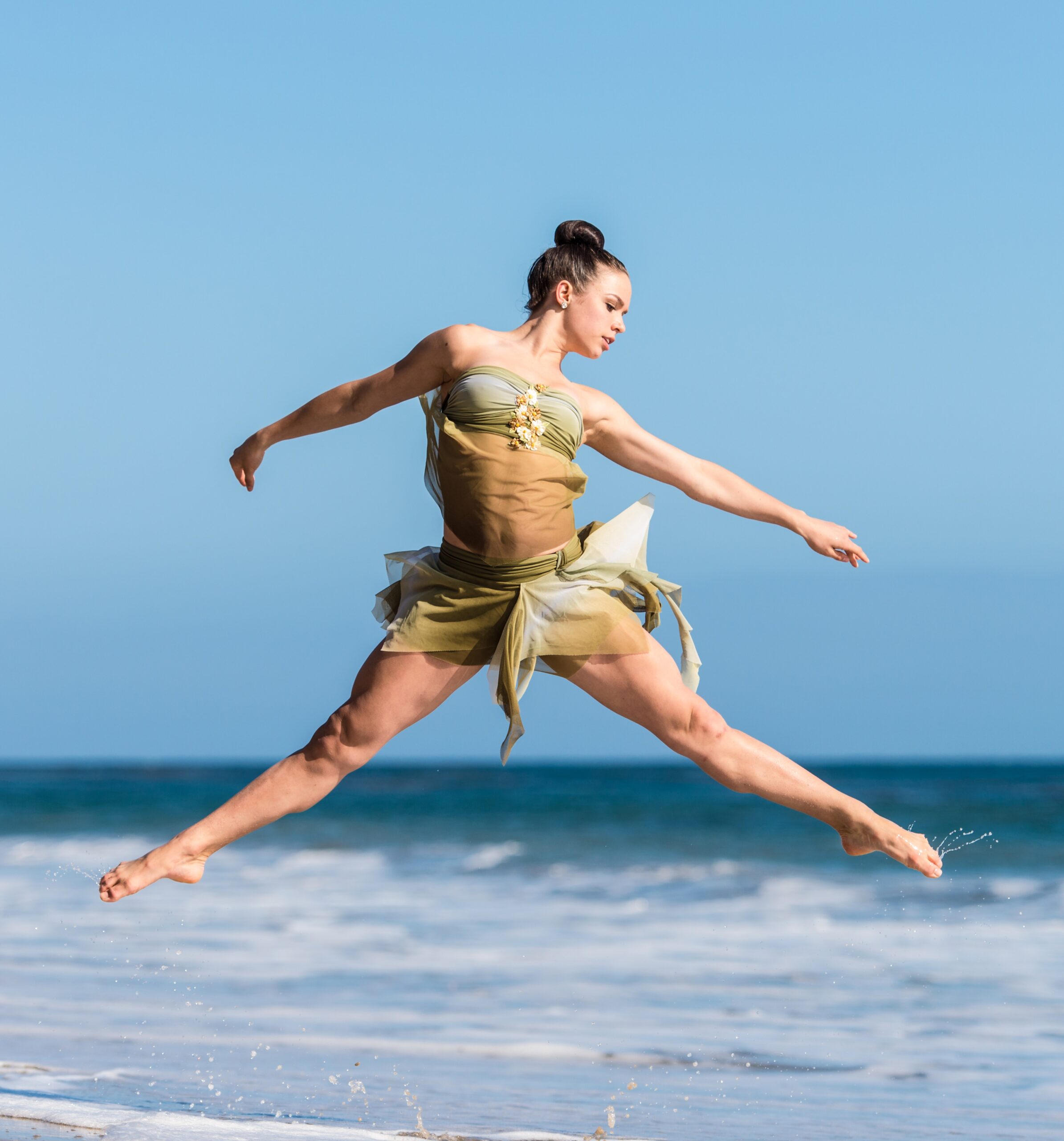 belly dancer jumping in front of ocean